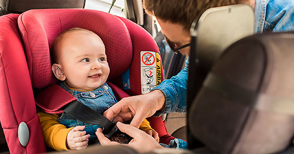 bebé en asiento de carro con papá